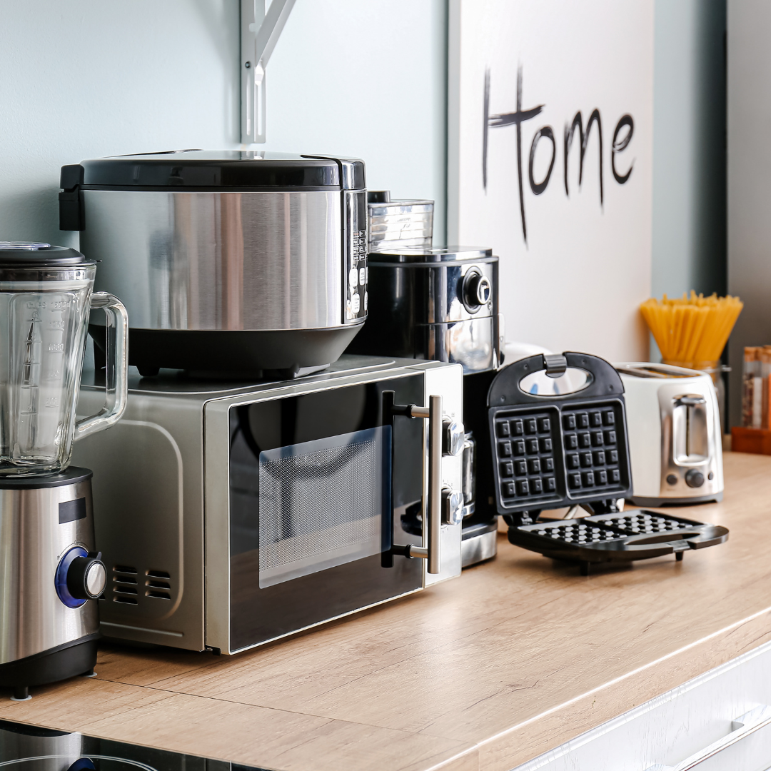 Cluttered kitchen benchtop covered in small appliances