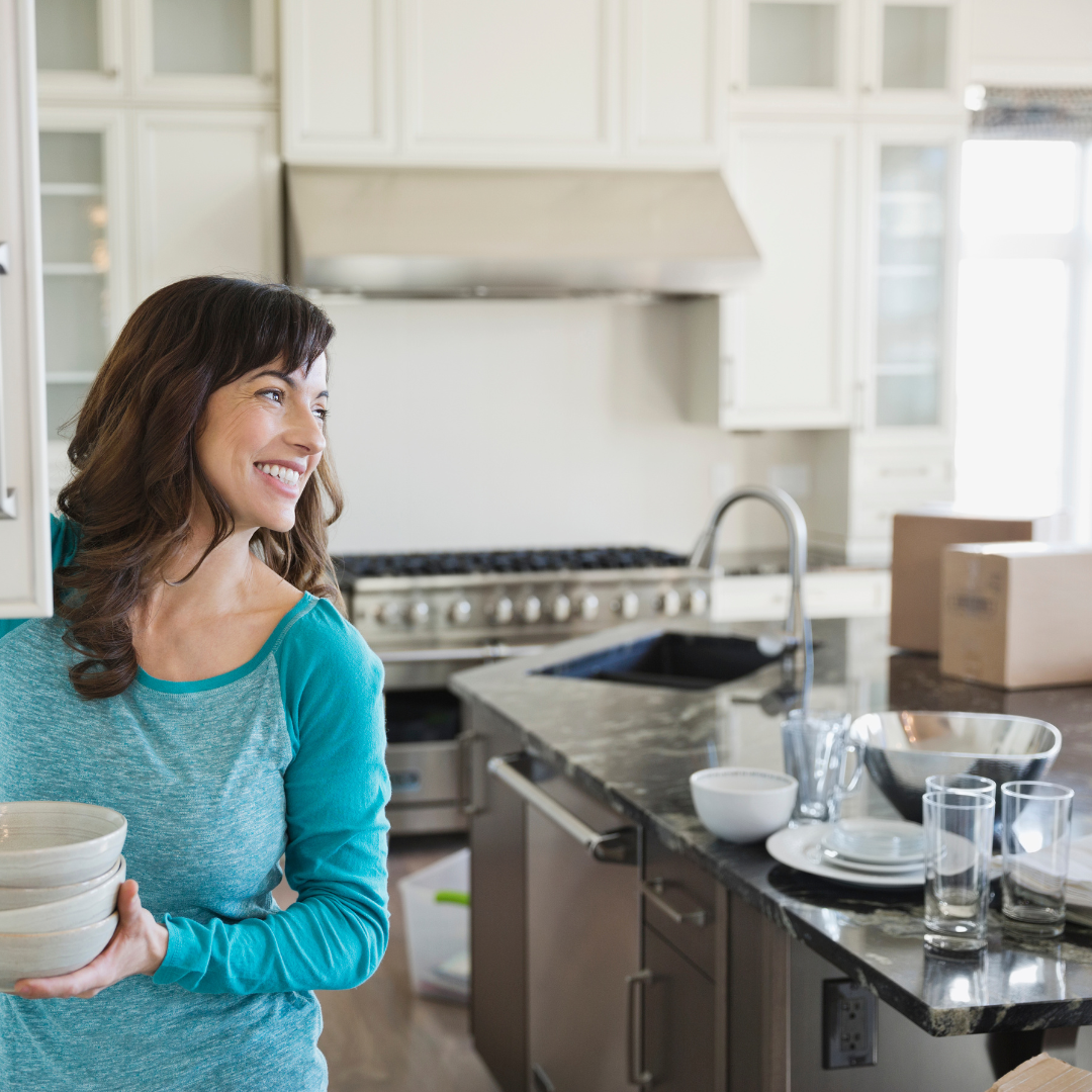 Kitchen items sorted into keep donate and bin piles during a cabinet clear-out